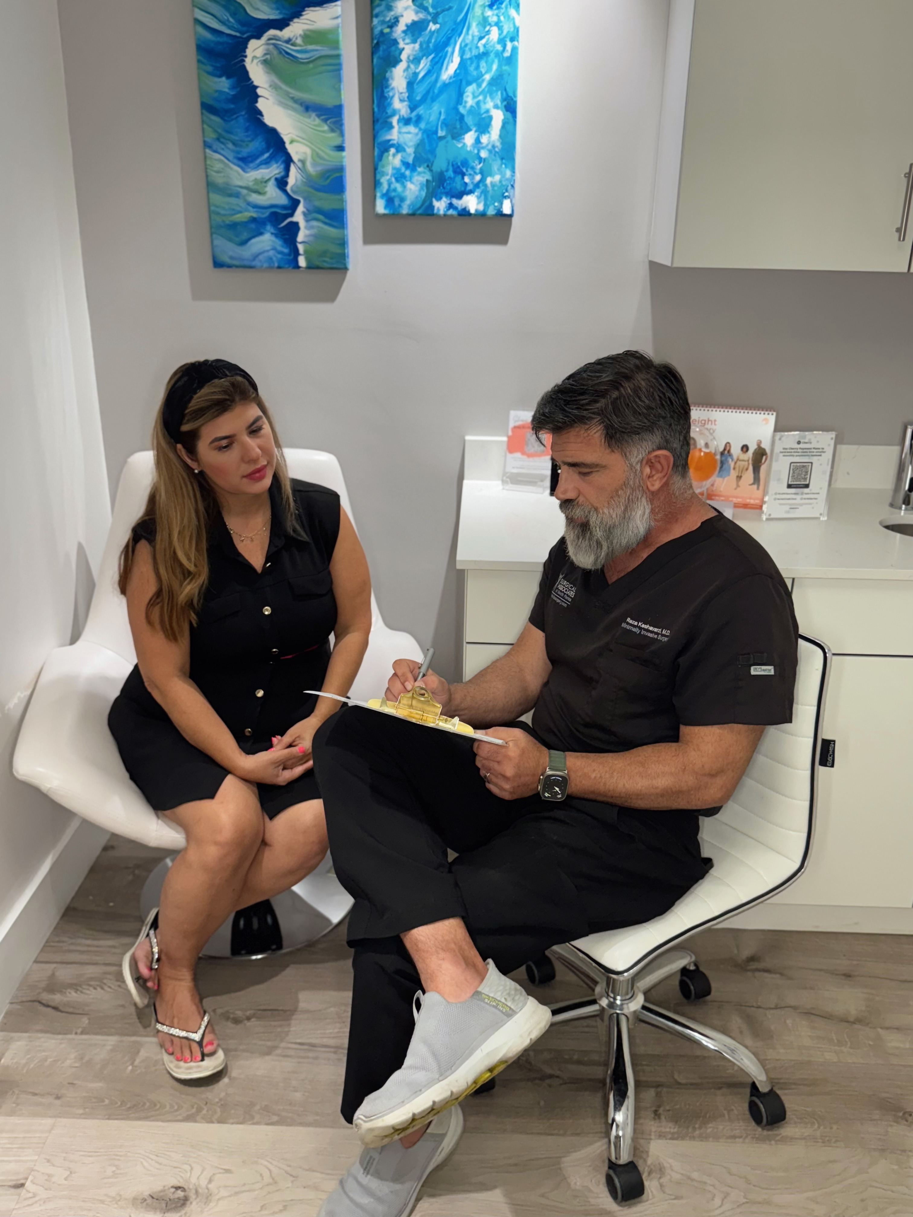Dr. Reza Keshavarzi reviewing notes with a patient during a consultation in an exam room