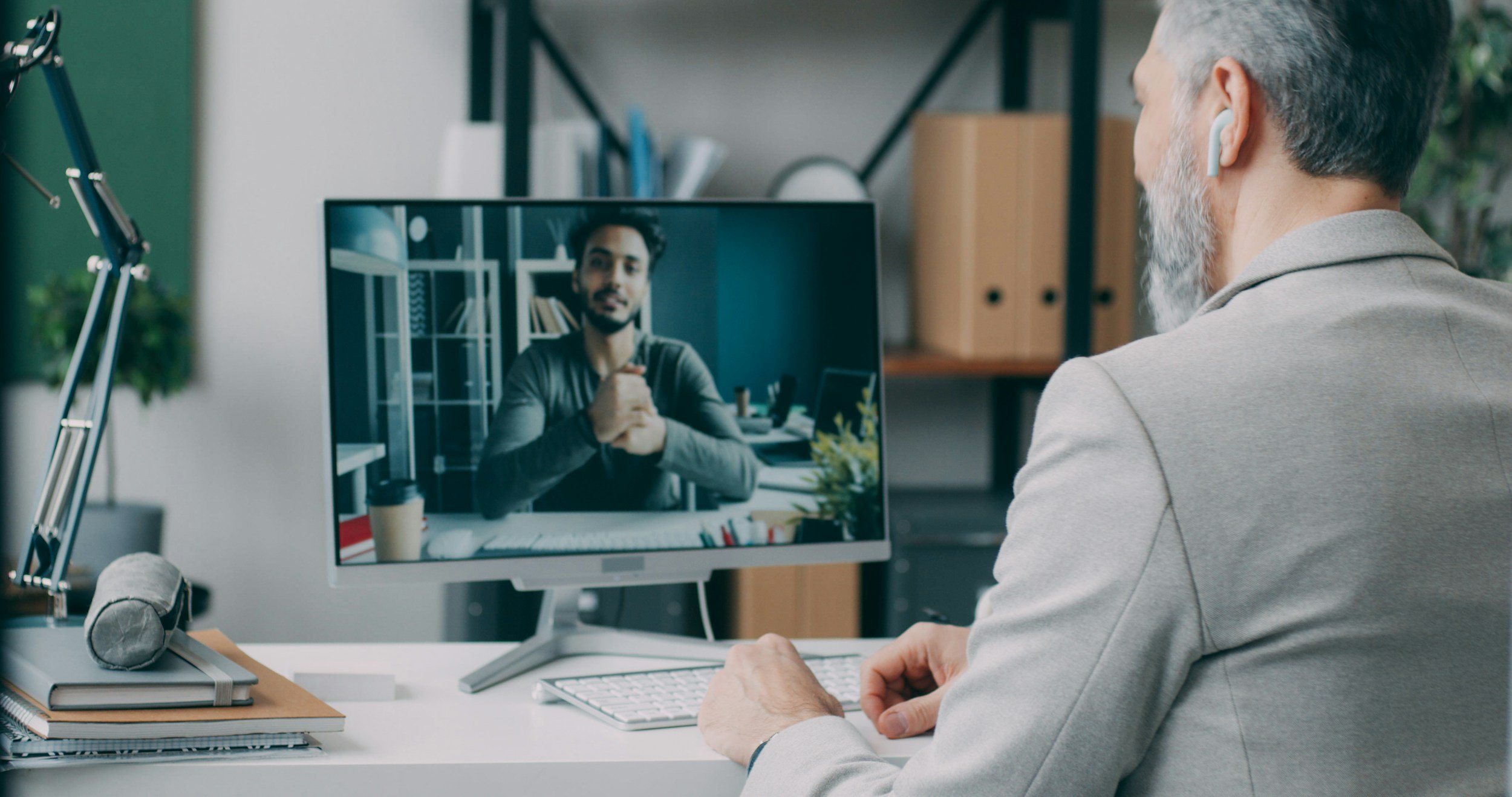 A man on a telehealth video call with his provider from a home office