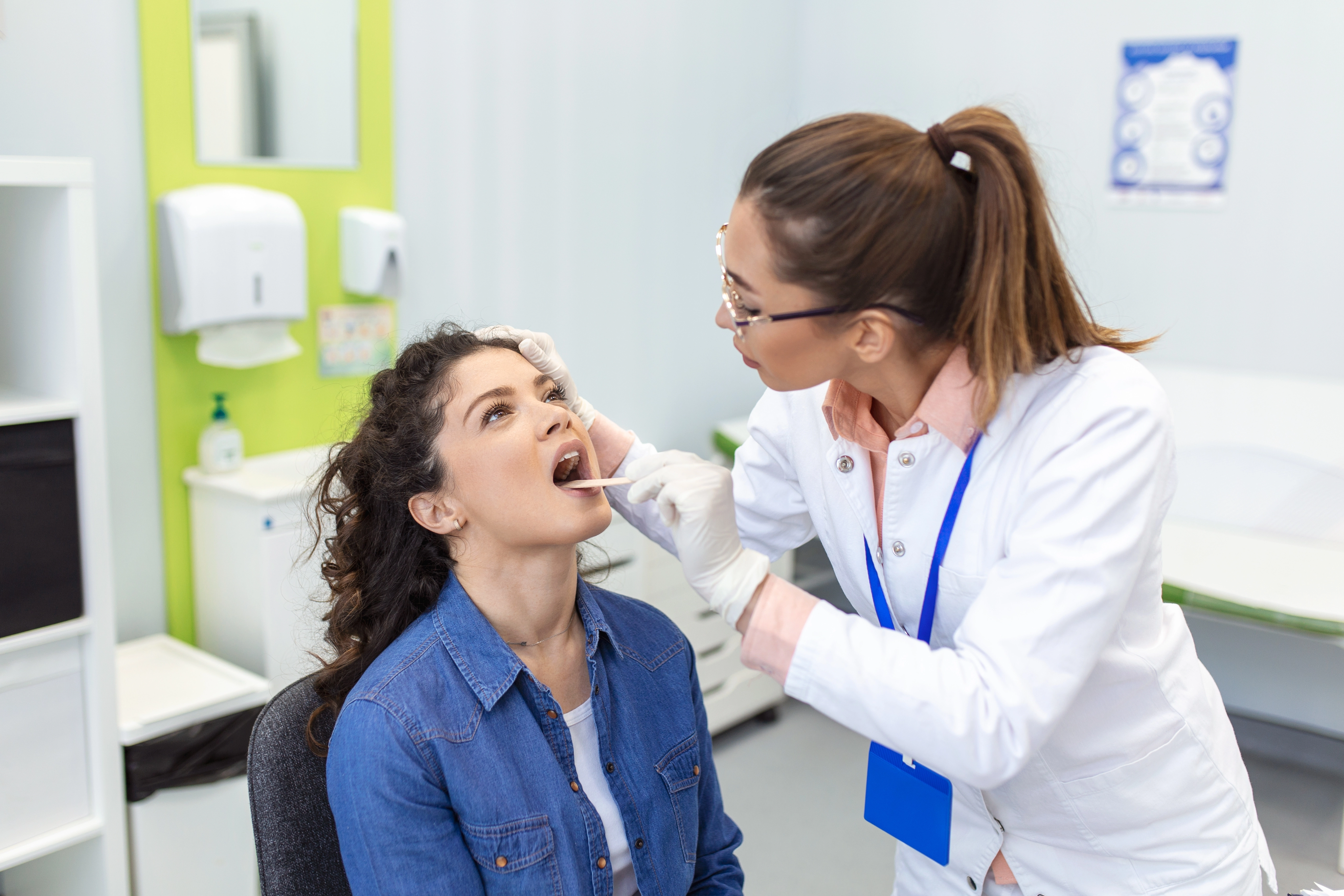Clinician examining a patient mouth during an oral cancer screening