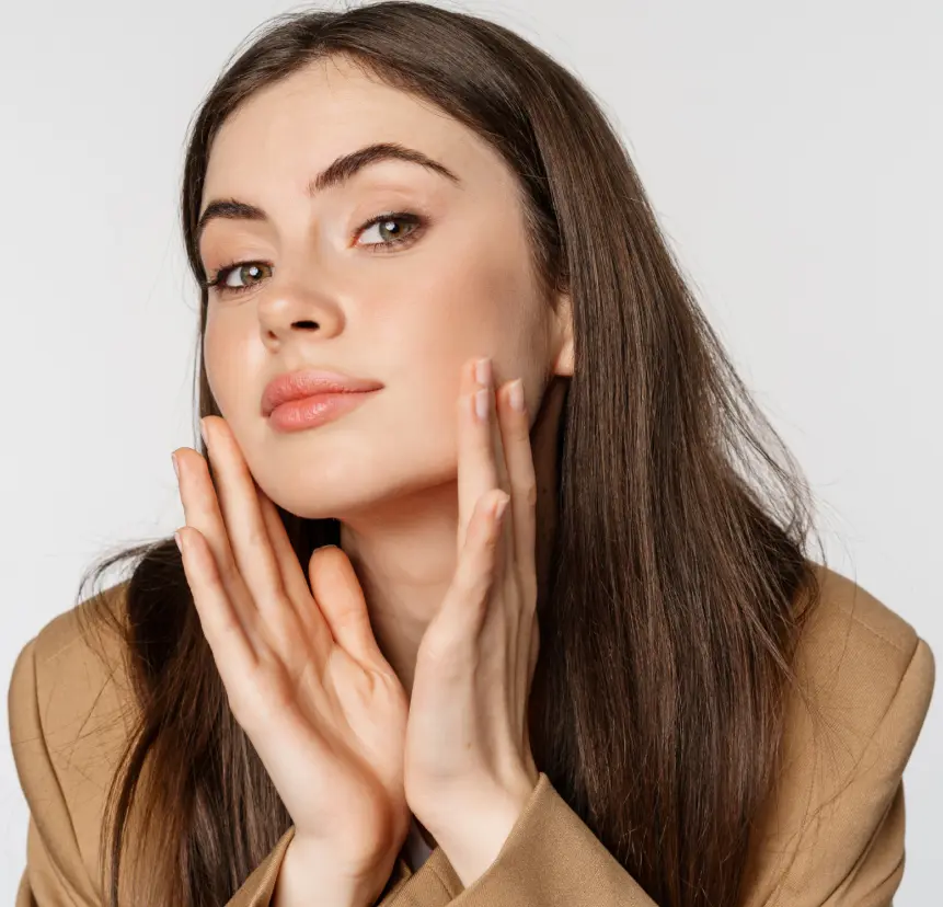 Woman with smooth skin gently framing her cheeks and jawline with both hands