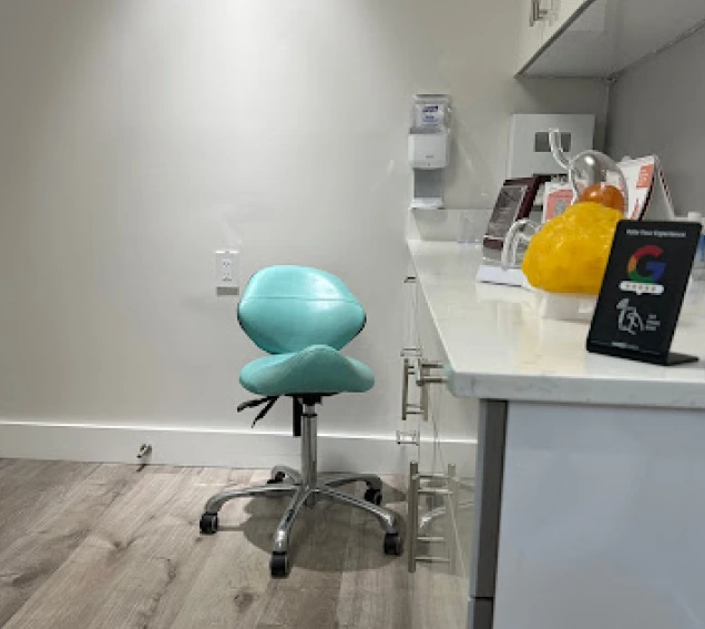 An exam room in our South Miami office with a teal stool and a countertop with supplies