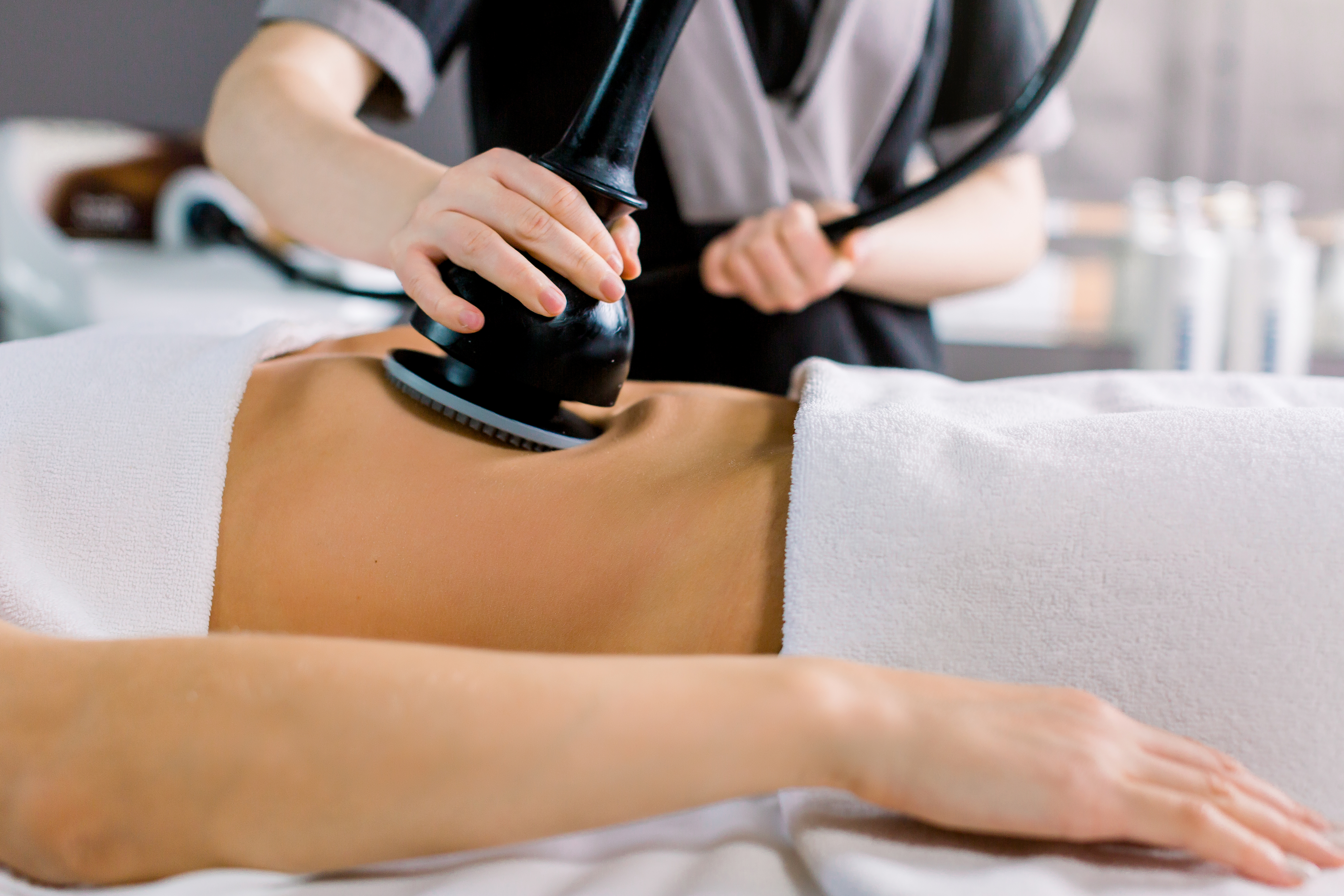 A provider performs a body contouring treatment on a patient's abdomen using a handheld cavitation device