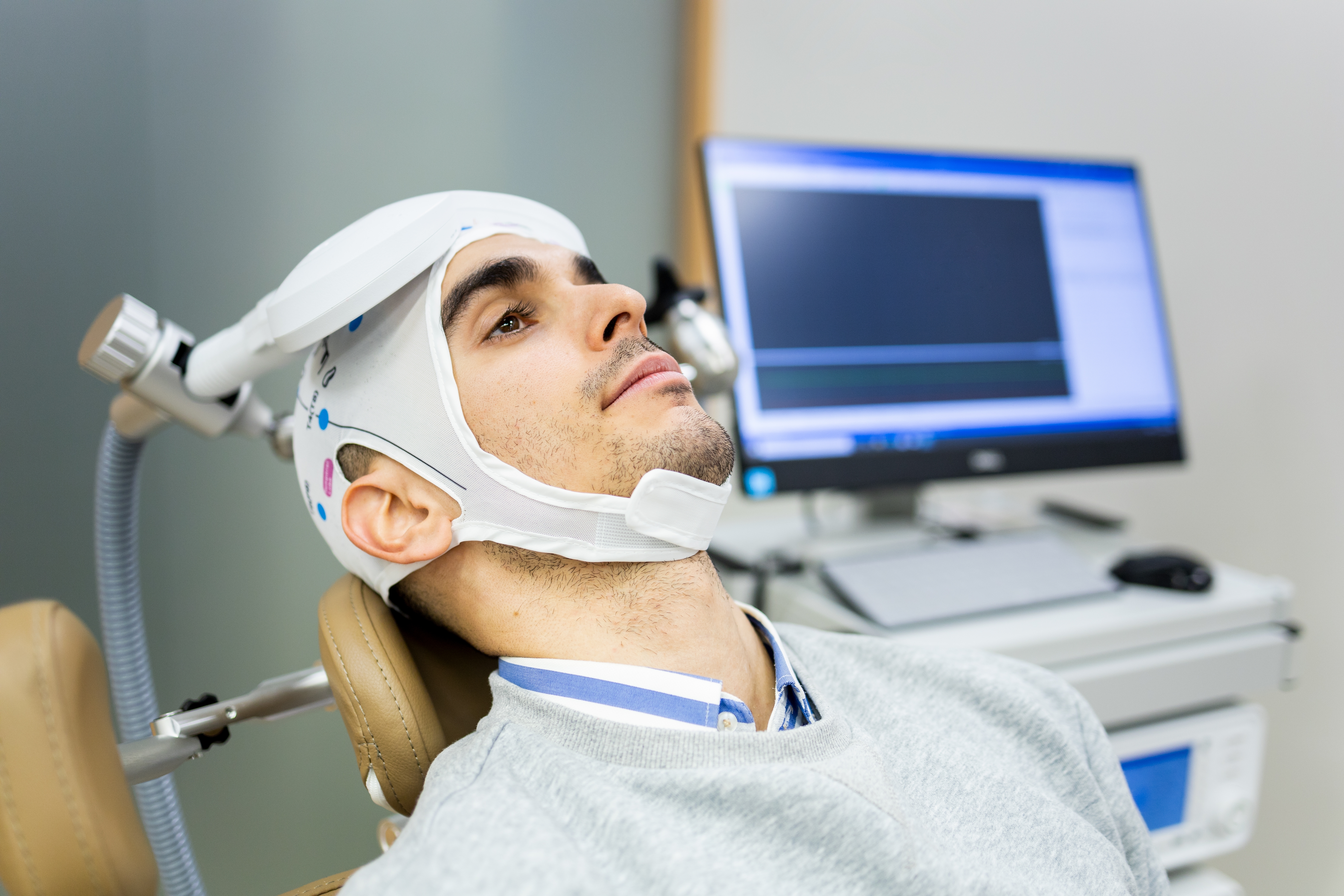 A patient reviewing progress with a provider during a follow-up visit after a course of TMS.