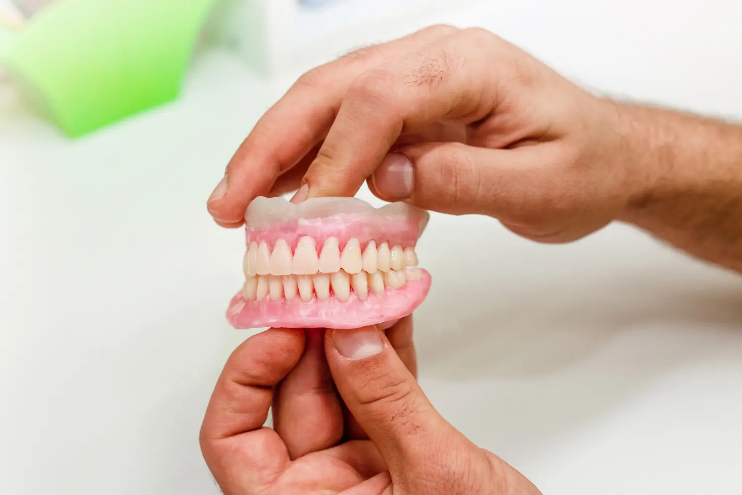 Full removable denture held in hands