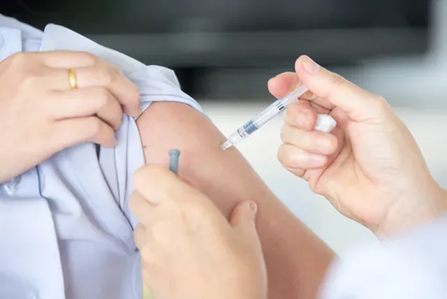Close-up of a clinician administering an injection into a patient's upper arm, illustrating IM ketamine therapy