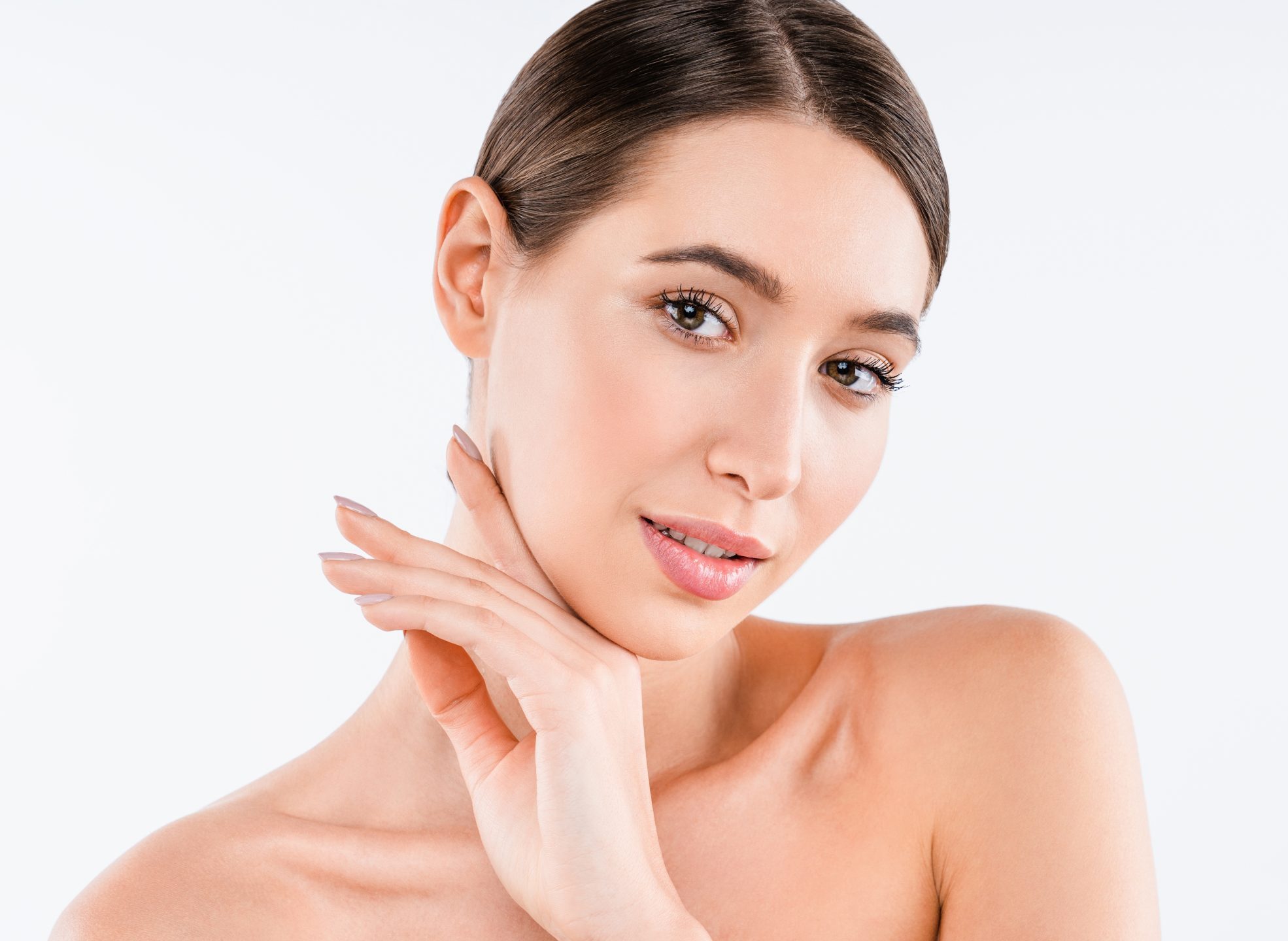 Studio beauty portrait of a young woman with flawless skin touching her neck, used to illustrate an IPL photofacial treatment