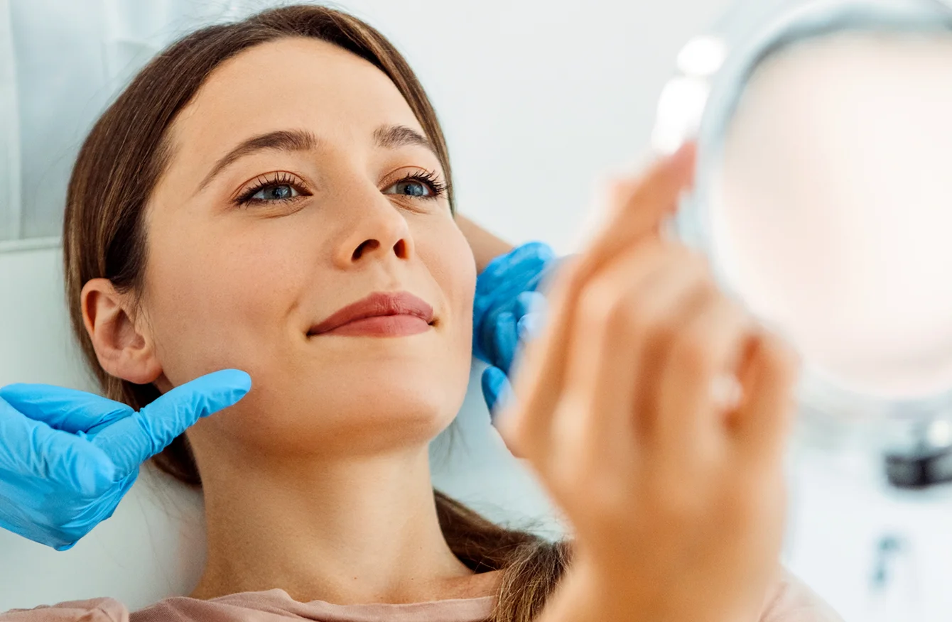 provider examining a patient's chin and jawline during a consultation
