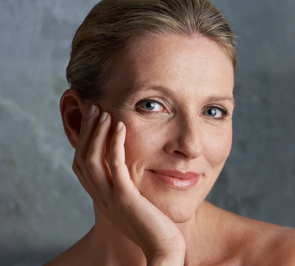 Smiling mature woman resting her cheek on her hand