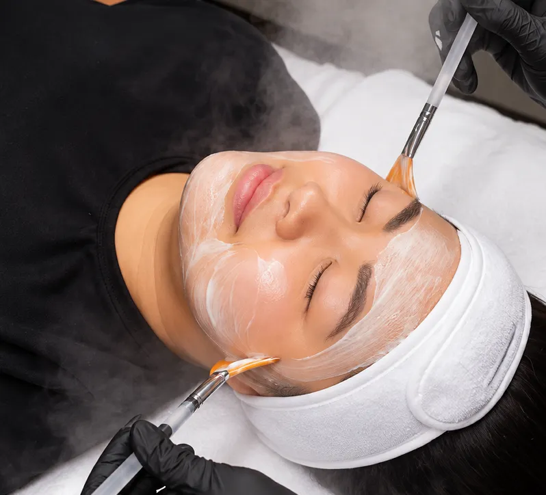 Brush applying a facial mask during a DiamondGlow facial