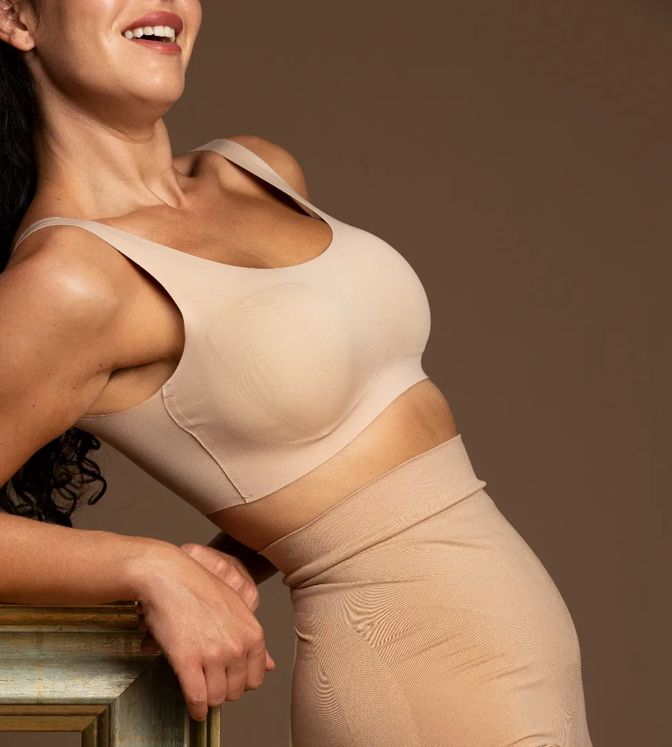 Confident woman in a fitted top leaning against a ledge