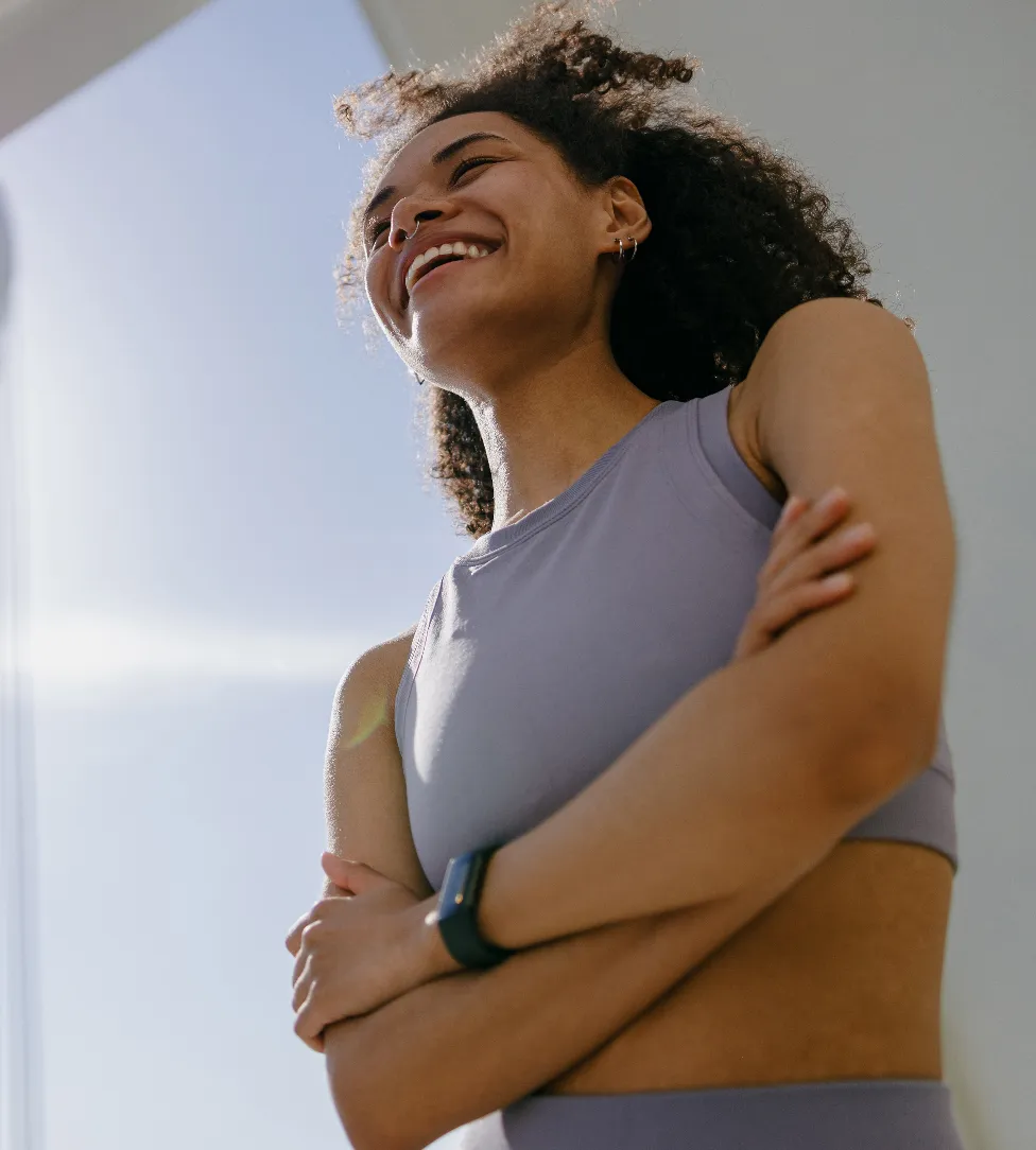 Woman in workout clothes smiling in the sunshine