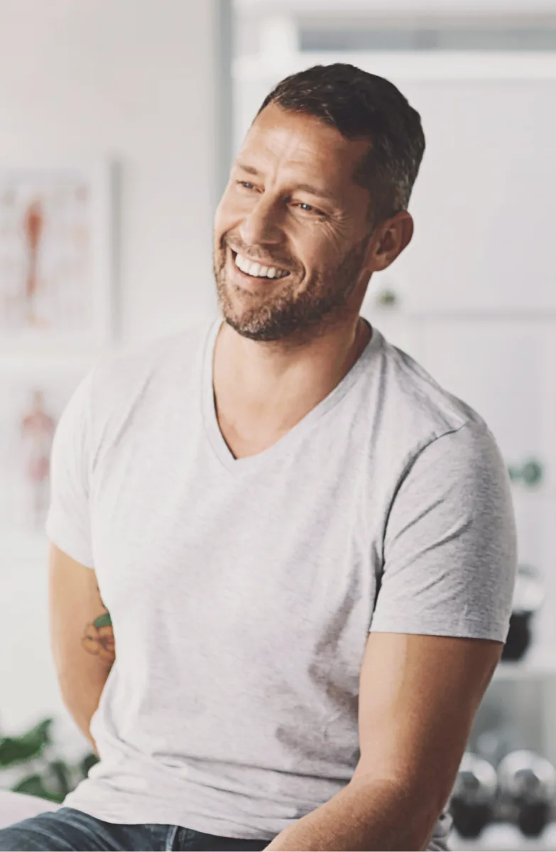 Man smiling in casual gray t-shirt in clinical setting