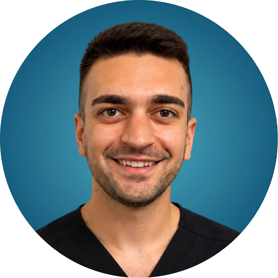 Male team member smiling at camera against blue background