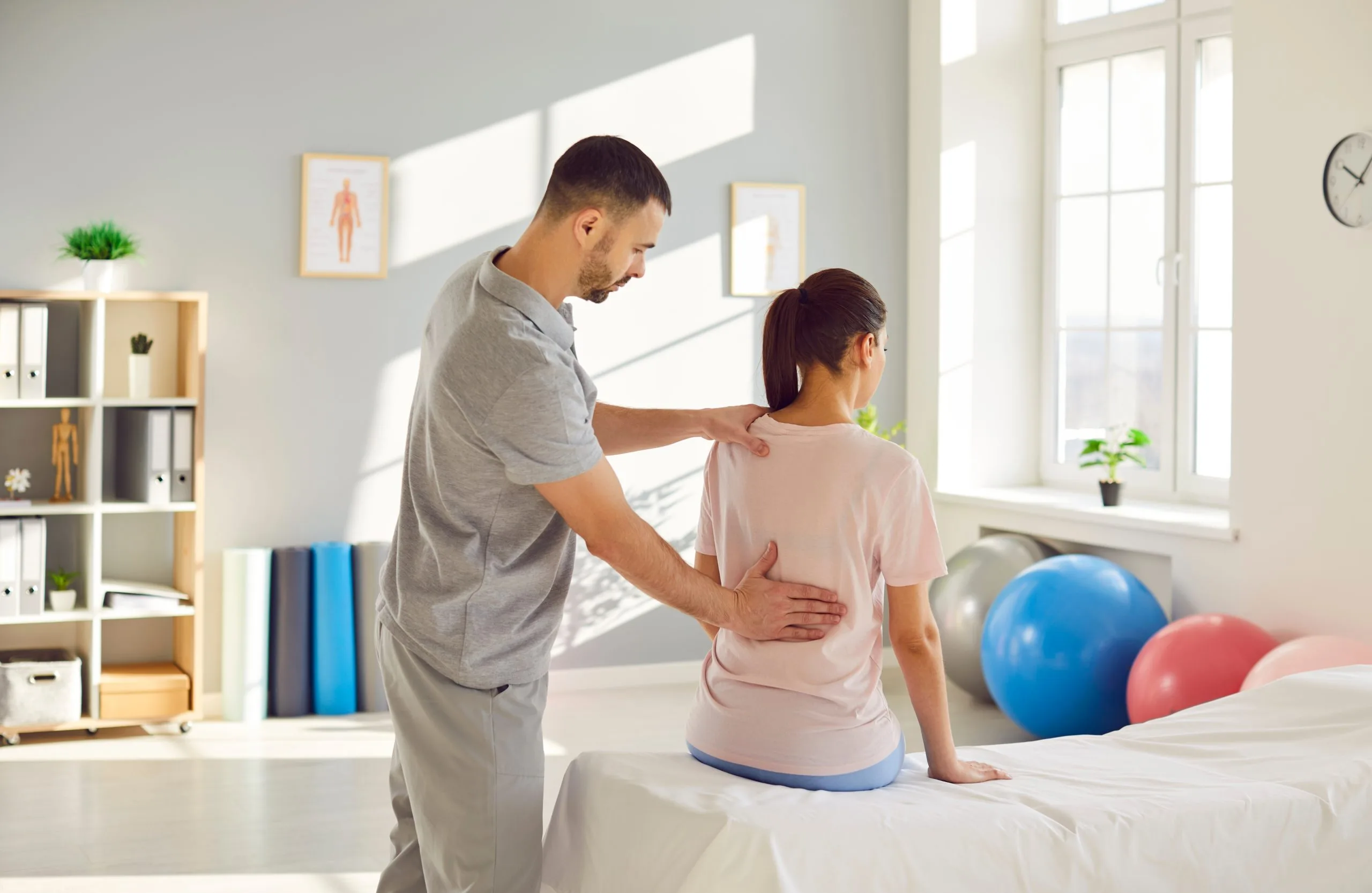 Physical therapist guiding a patient through a lower back exercise