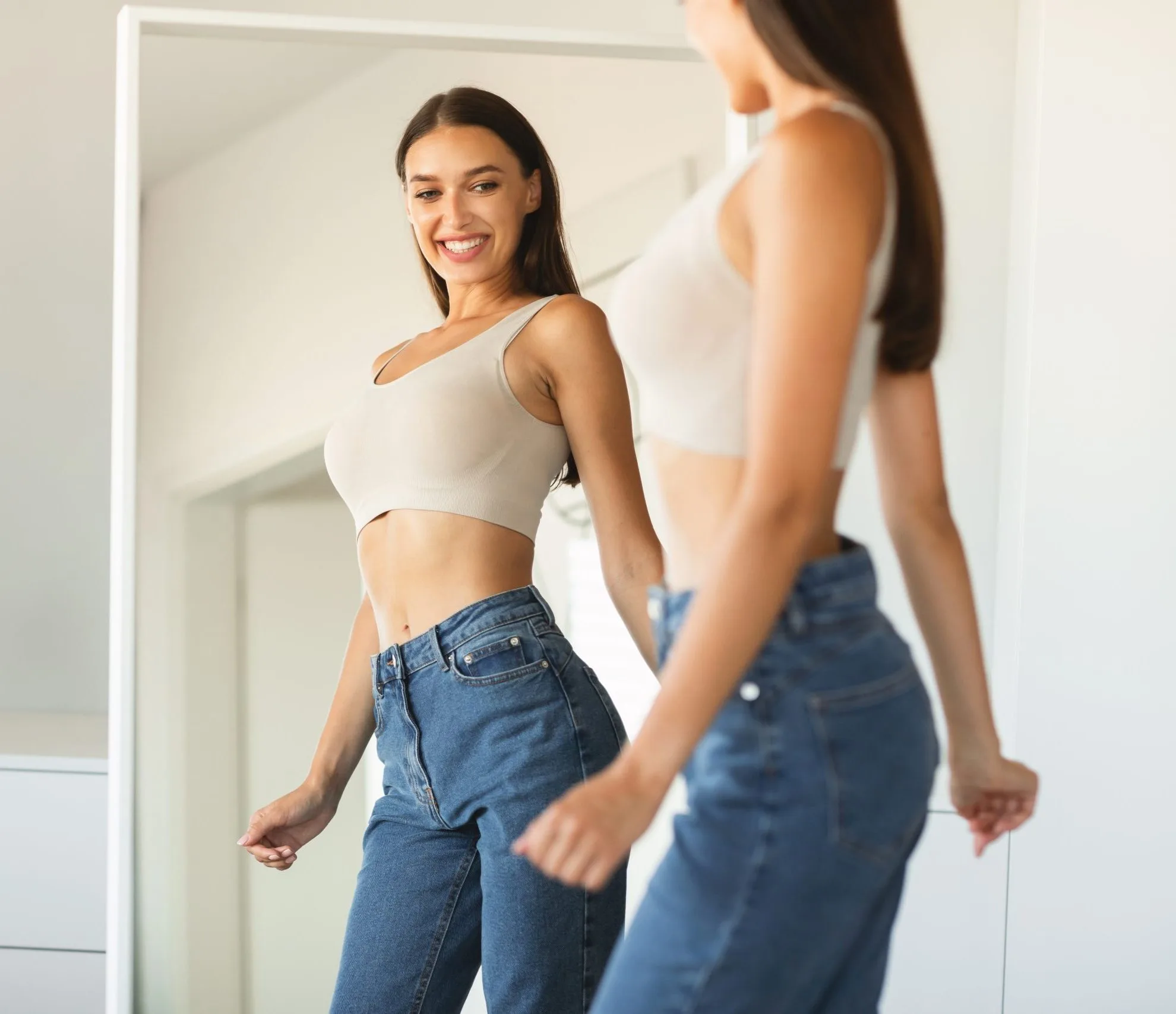 Woman smiling at her reflection in a mirror