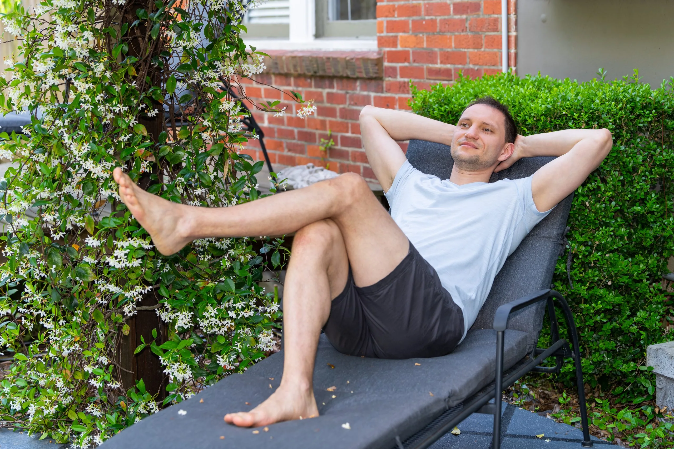 Man relaxing on a lounge chair in a residential patio setting