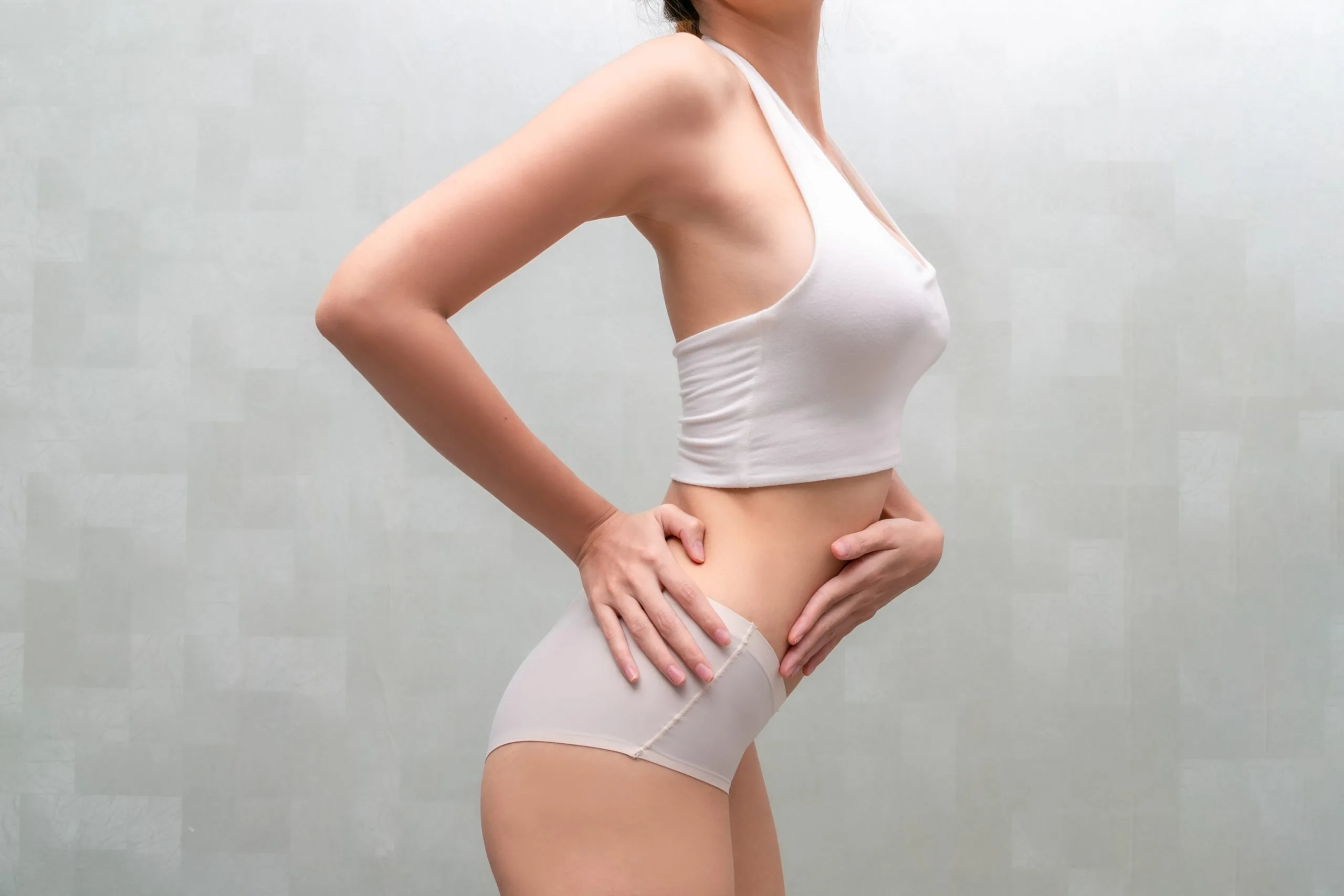 Woman in white undergarments displaying her body contours from the side