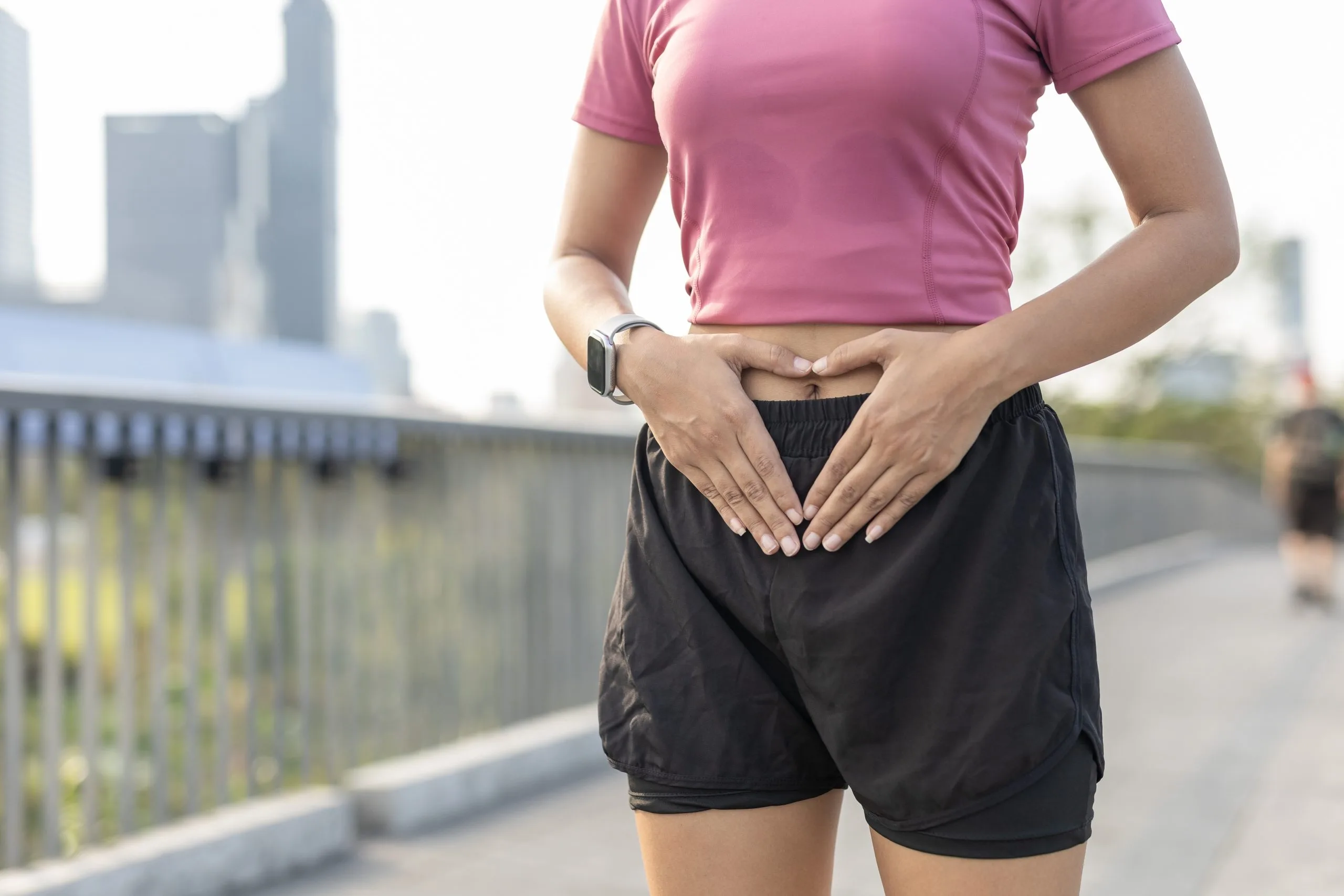 Woman in sportswear touching her lower abdomen