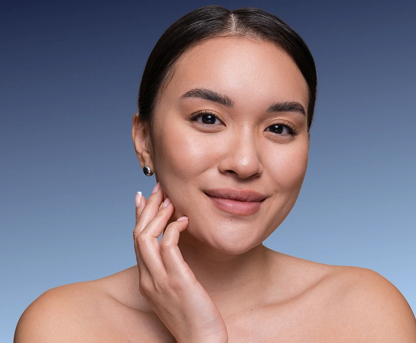 Woman touching her cheek with a smile against blue background