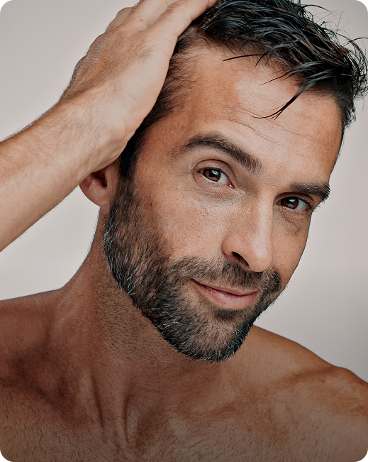 Man touching his hair and face demonstrating wellness treatment benefits