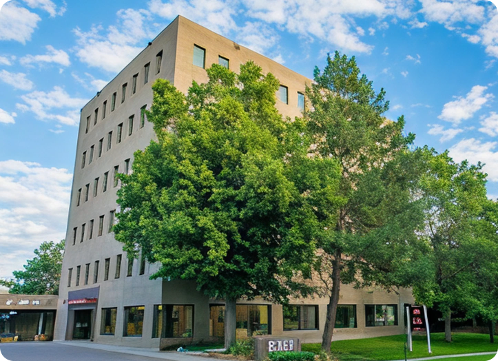 Brilliant Family Dentistry Main Office exterior in Denver, CO, a multi-story tan building with large windows and mature trees