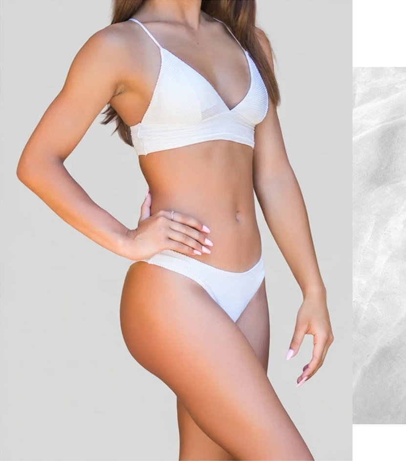 Woman in white bikini displaying toned torso and body contours
