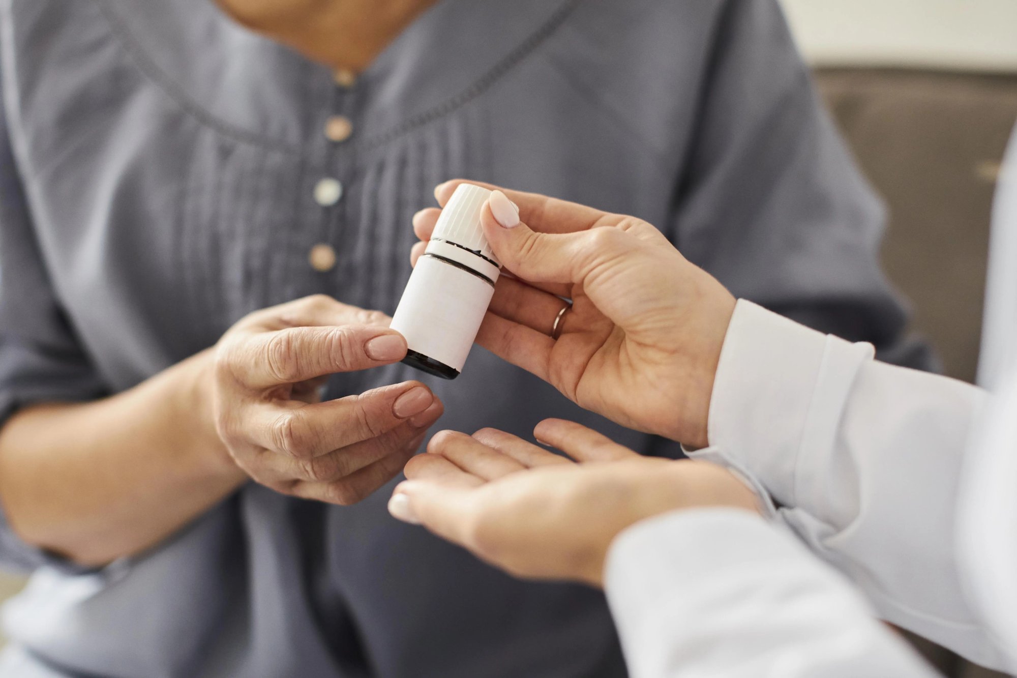 Pharmacist handing a prescription bottle to a patient, compounding pharmacy serving Duluth, GA