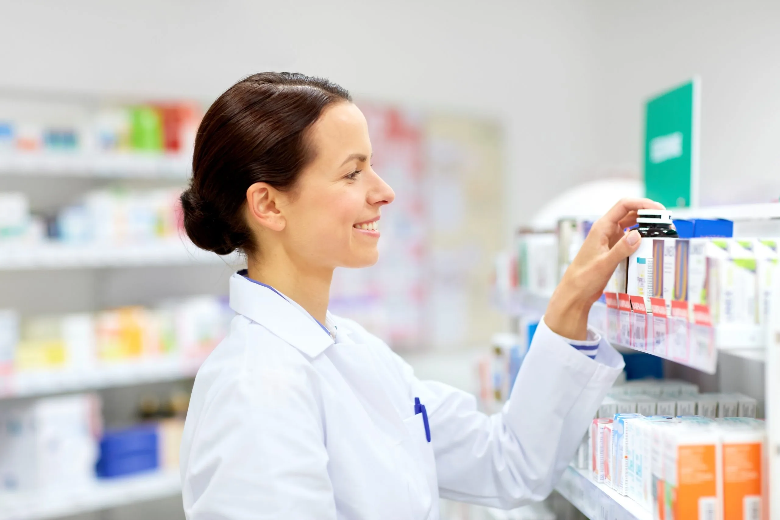 Pharmacist selecting medication from shelf in compounding pharmacy