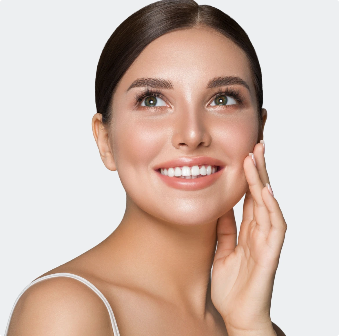 Woman smiling with hand to face, showing healthy white teeth