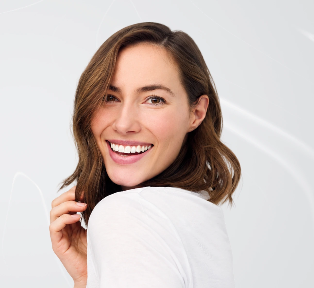 Woman smiling at camera with healthy teeth and jawline