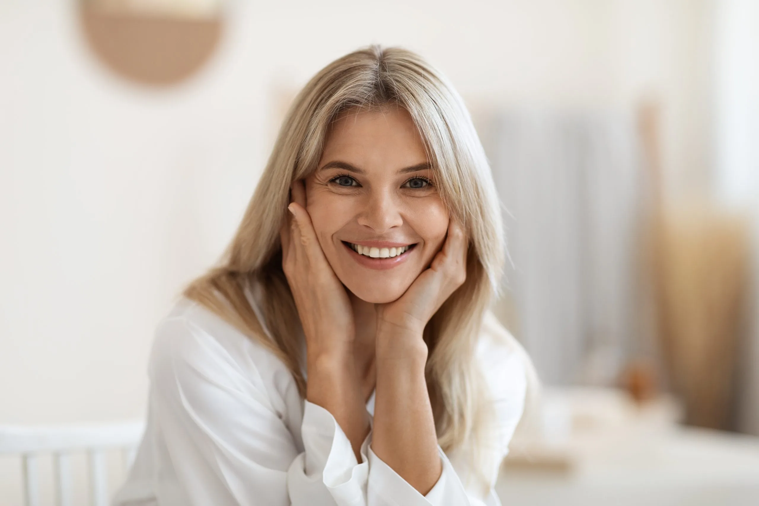 Smiling mature woman with restored teeth following sinus lift and dental implant treatment in Denver