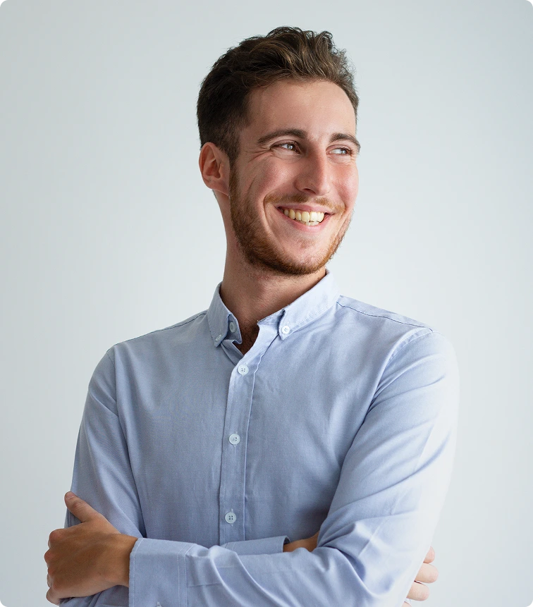 Man smiling at camera in light blue button-up shirt against neutral background