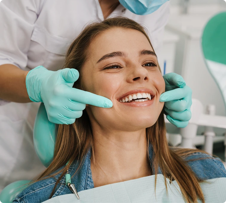 Clinician in turquoise gloves examining a smiling patient's face during PRP therapy consultation in Denver