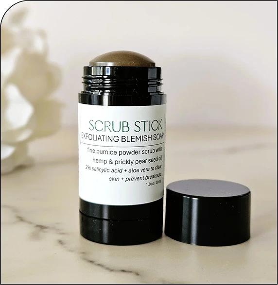 Scrub Stick exfoliating blemish soap product with black cap and white label on marble surface