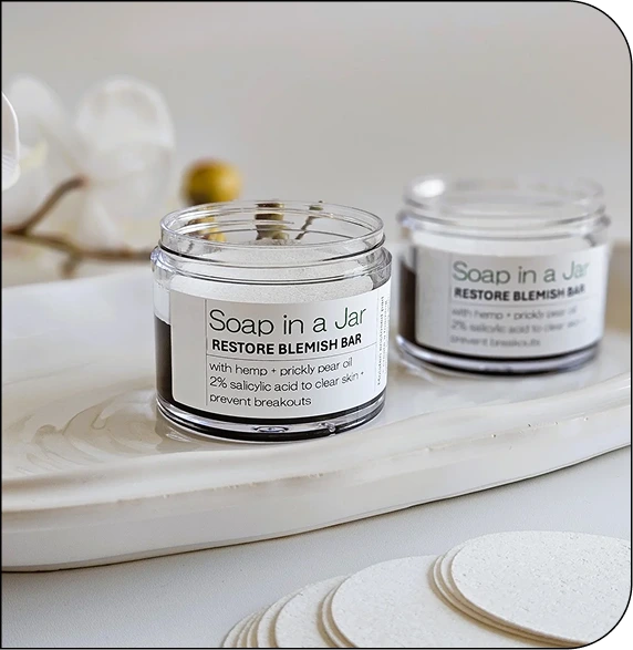 CNT Soap in a Jar Restore Blemish Bar displayed in glass jars with product label visible