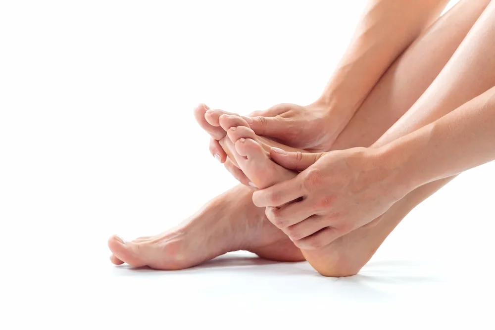 Hands gently massaging bare feet during a foot spa