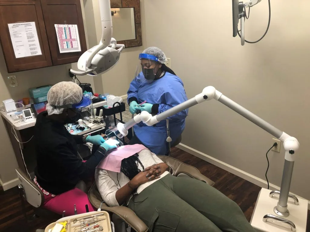 Dental staff treating a patient during a hygiene visit at Advanced Dentistry of Collegeville