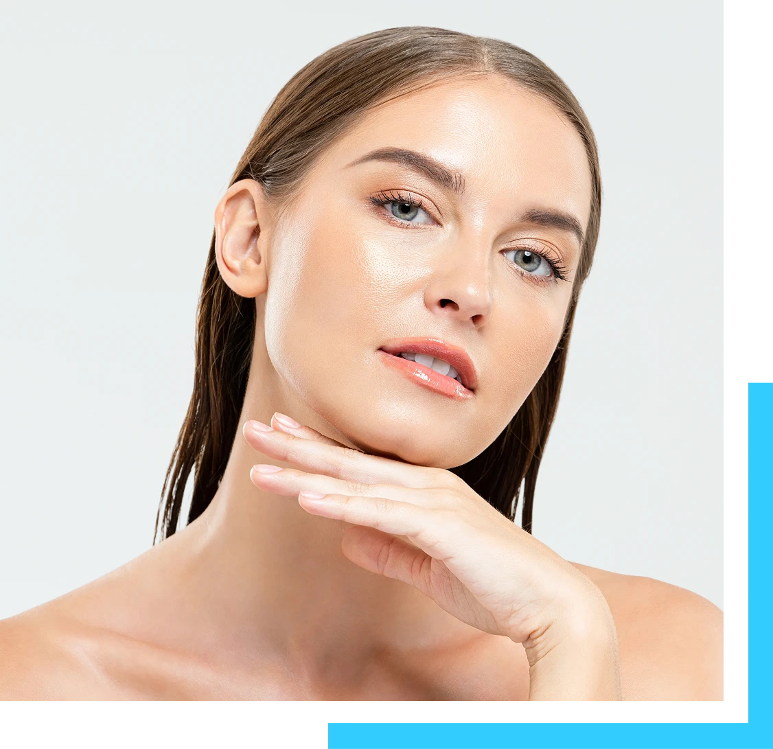 Woman with smooth, radiant skin touching her chin and cheek against a neutral background