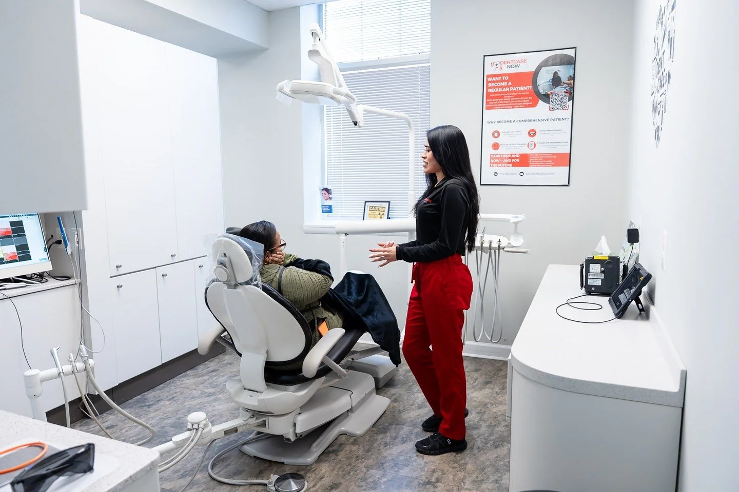 Dentcare Now team member talking with a patient holding her jaw in a Fairfax, VA treatment room