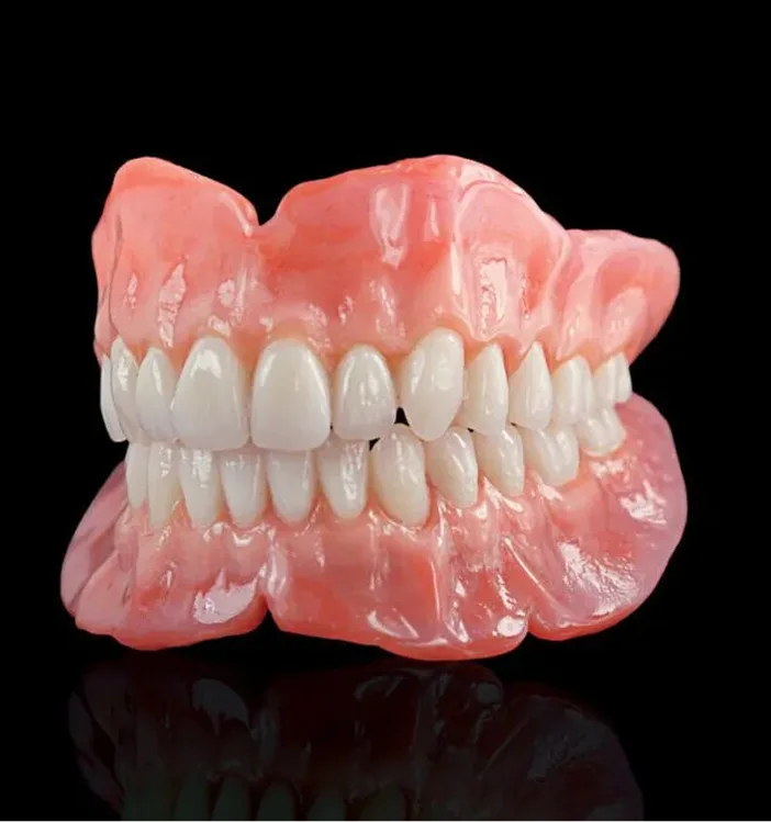 Complete upper and lower dentures with pink gum-colored base and white artificial teeth