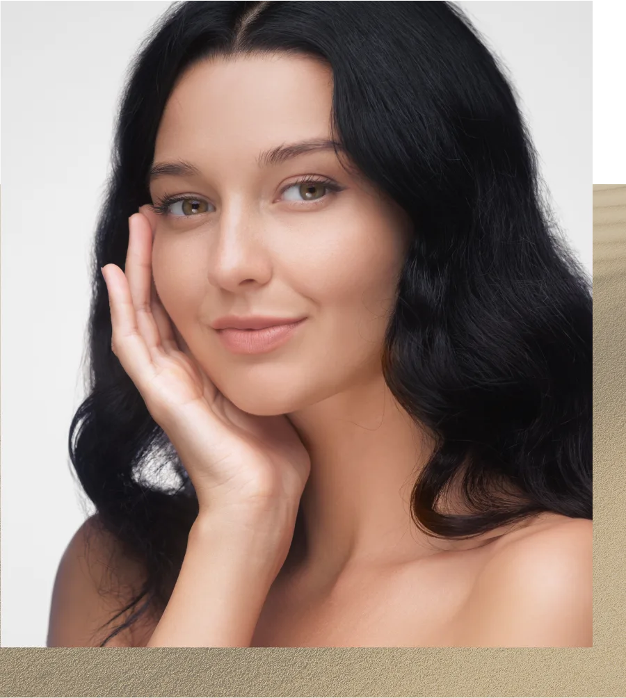 Woman with long black hair touching her face, smiling at camera