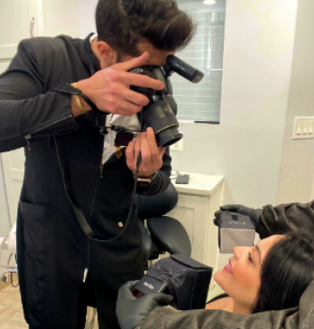 Photographer capturing intraoral images of patient's teeth with specialized dental camera