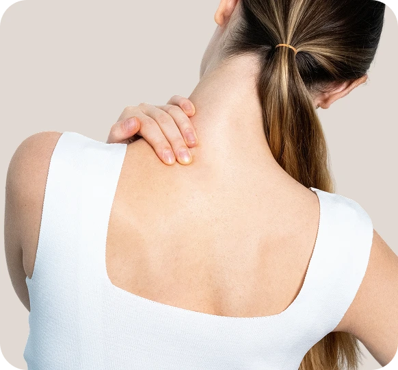 Person touching back of neck and shoulder with other hand, hair pulled up
