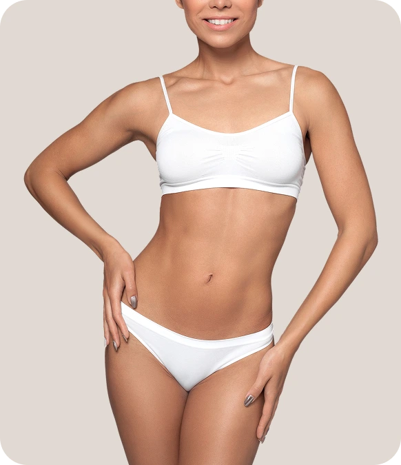 Woman displaying toned arms and torso in white bikini against neutral background