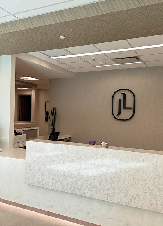 Jude LaBarbera MD Plastic Surgery reception desk with marble countertop and logo on wall