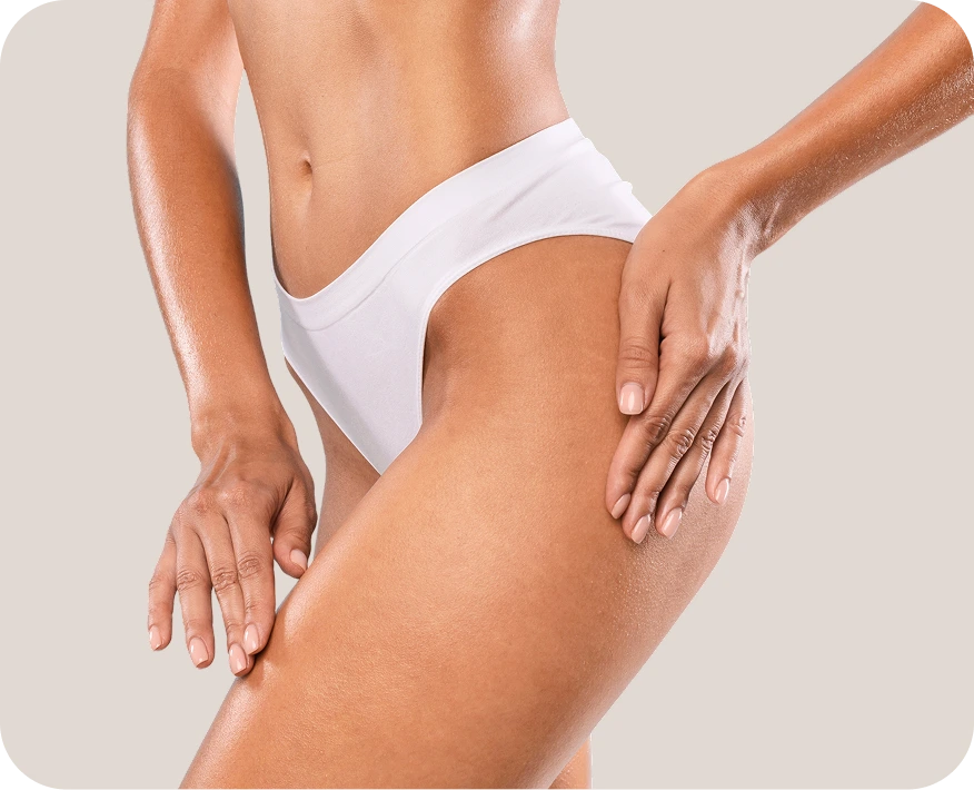 Woman examining her thigh and hip area, demonstrating skin firmness and contour