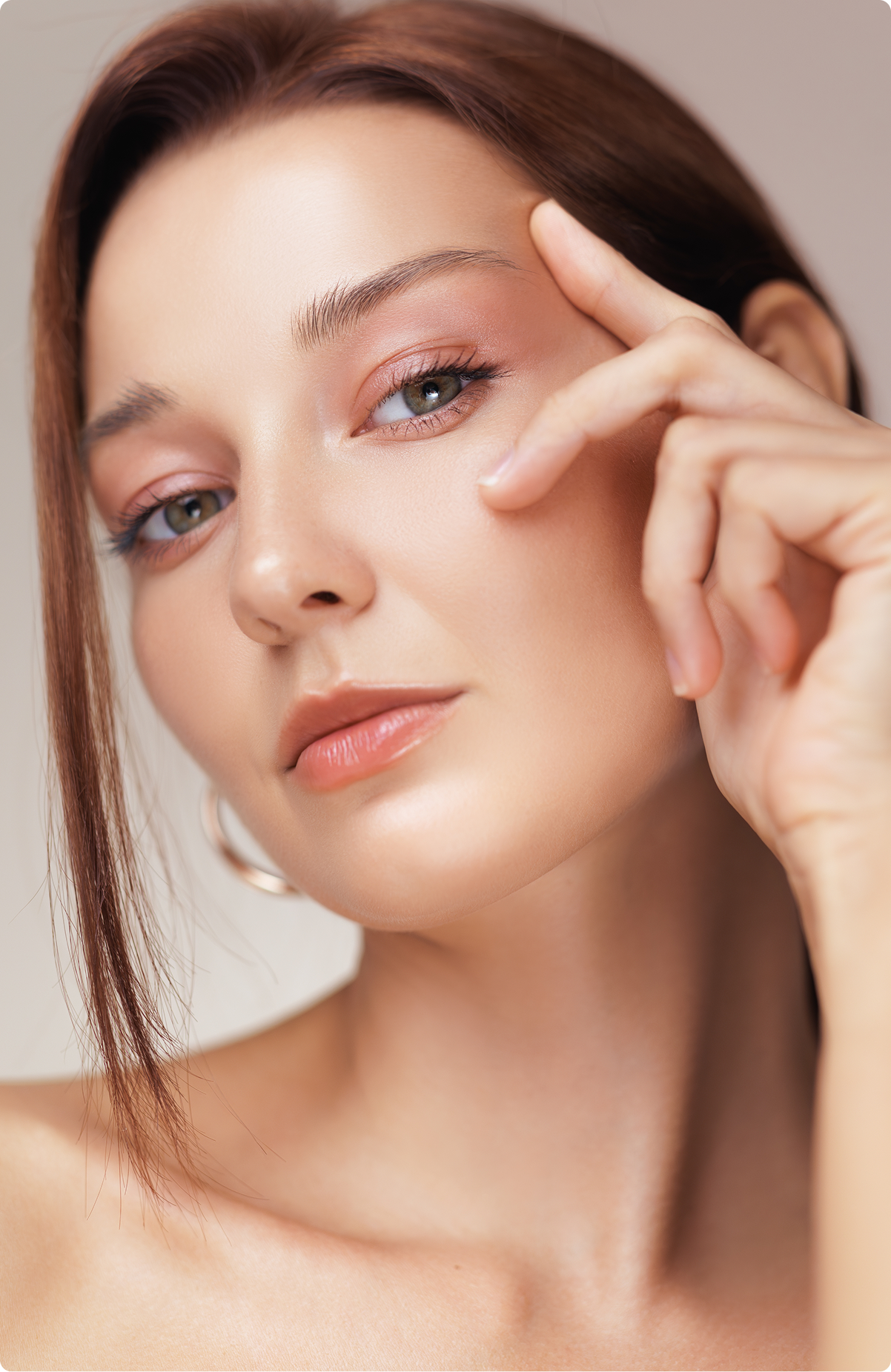 Woman pointing to her lower eyelid area during an eyelid surgery consultation