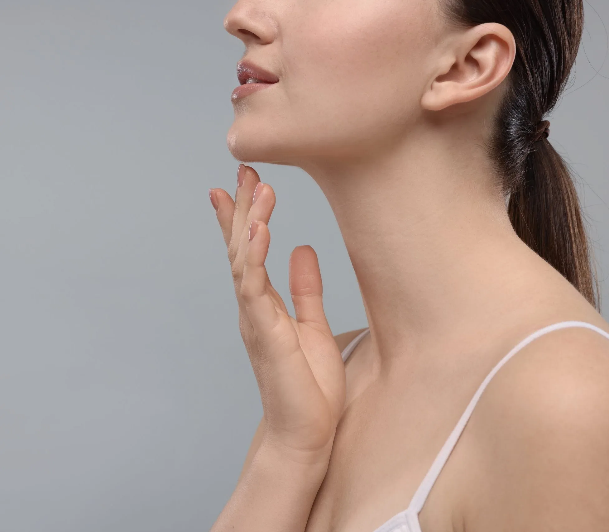 Woman touching her chin, illustrating chin contouring treatment options