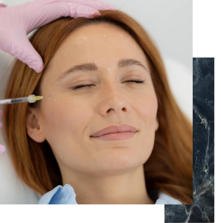 Clinician injecting dermal filler into patient's cheek during consultation