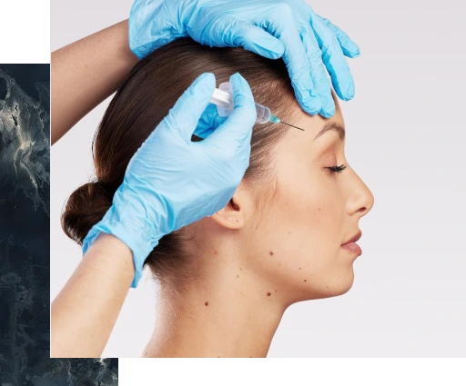 Gloved hands applying injectable filler to a patient's forehead during treatment
